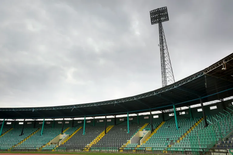 Empty stadium seats under a cloudy sky